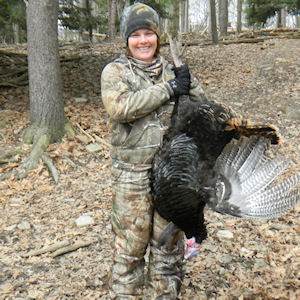 Woman posing with hunted turkey